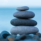 "rocks piled in a tower on a beach"