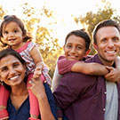 man and woman holding two children