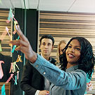 woman pointing at notes on a board