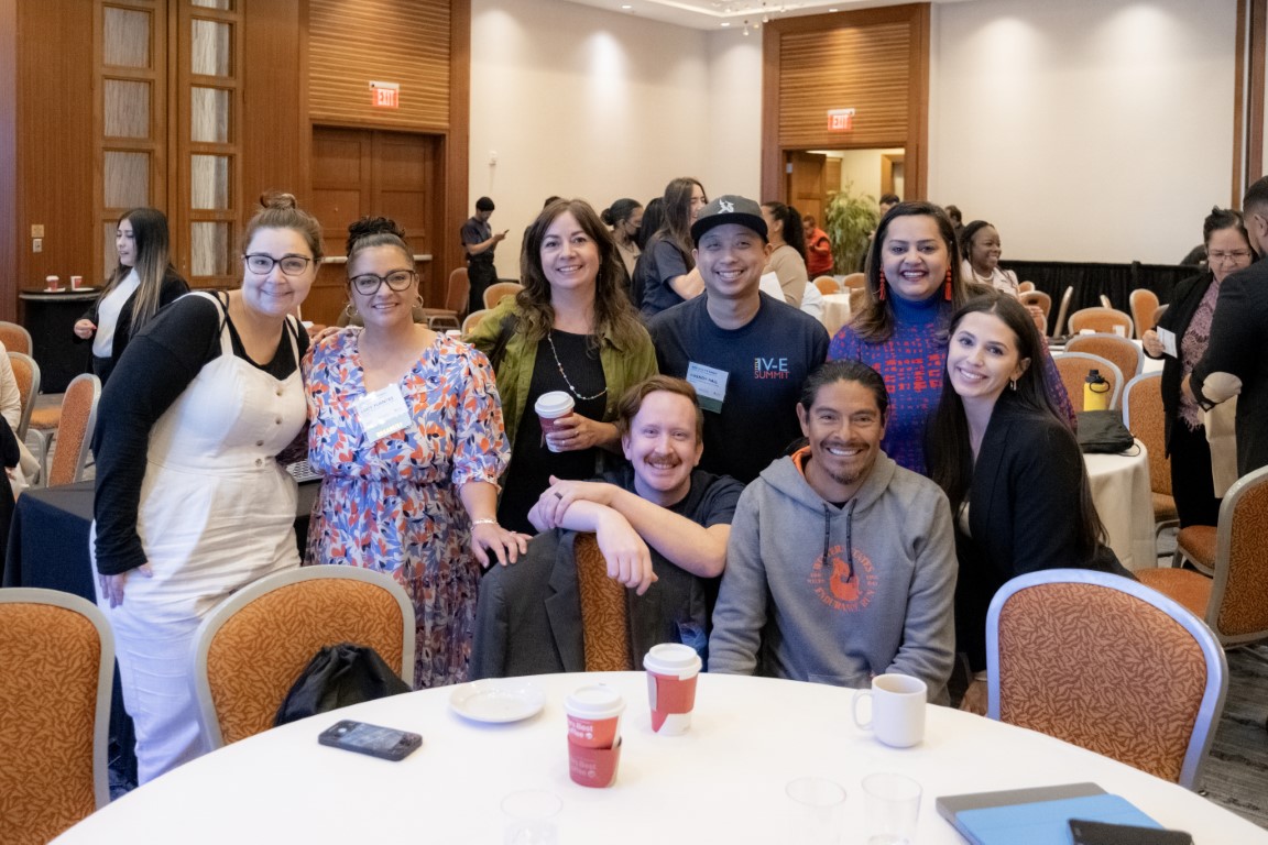 A group of Title IV-E Summit attendees gather in a banquet room following a plenary presentation