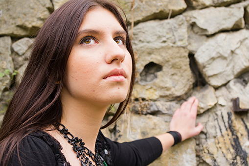 teenage girl leaning on rock wall