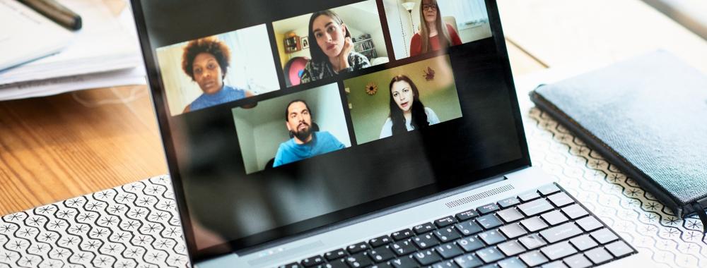 laptop displaying people in a Zoom meeting
