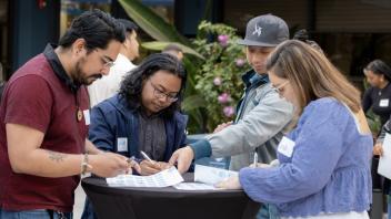 A group of Title IV-E Summit attendees gather around an outdoor table during a networking activity