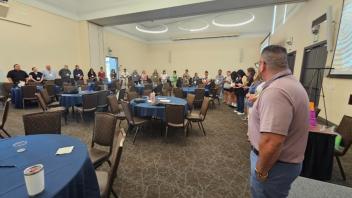Man standing in front of a crowd inside a conference hall