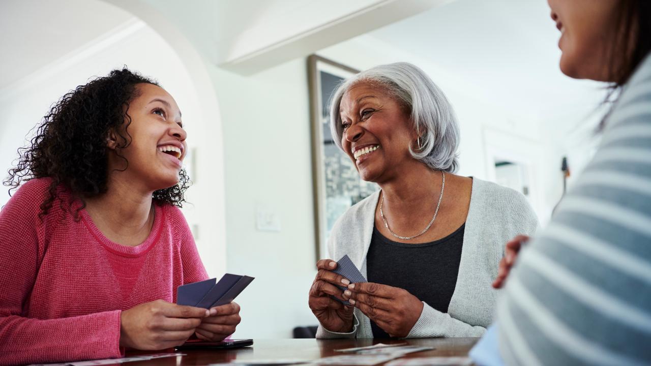 Two women smiling while playing a card game