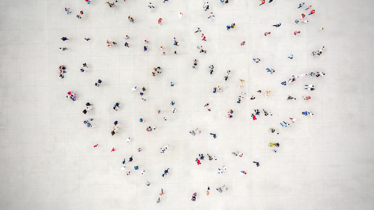 A group of people standing together in the collective shape of a heart.