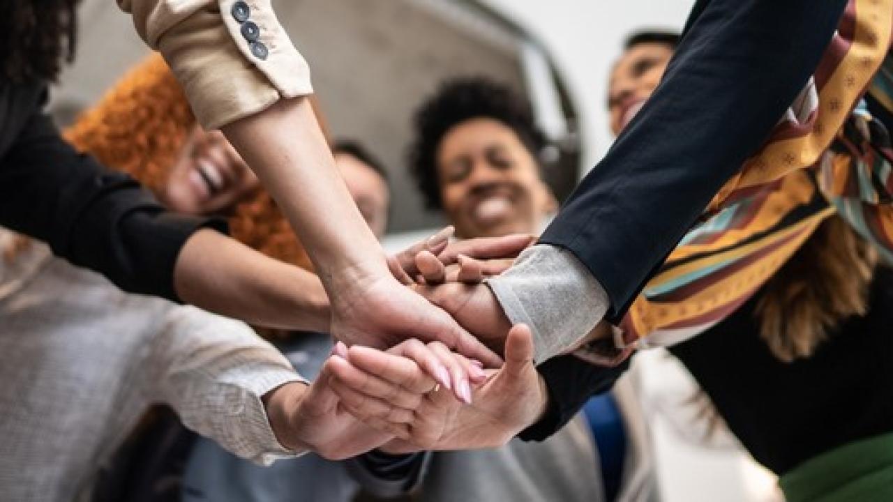 People in a circle putting their hands together