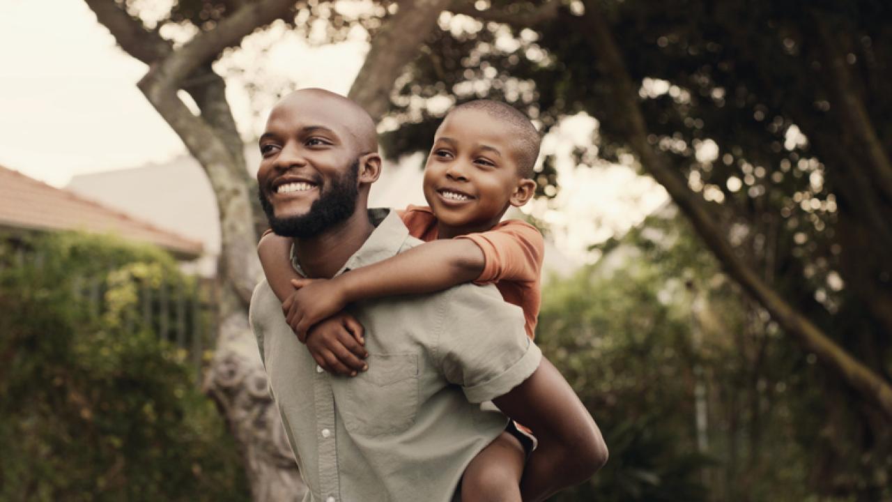 African Amaerican father with young son on his shoulders