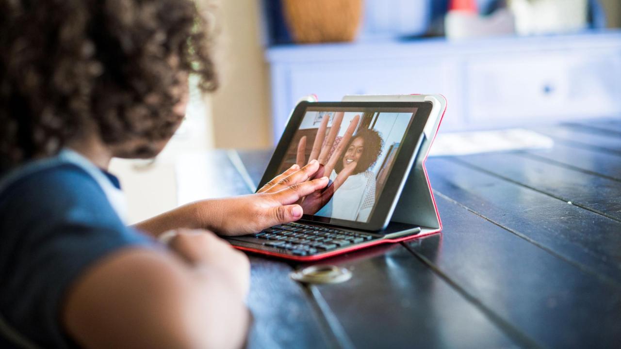 A person speaking virtually to others via laptop