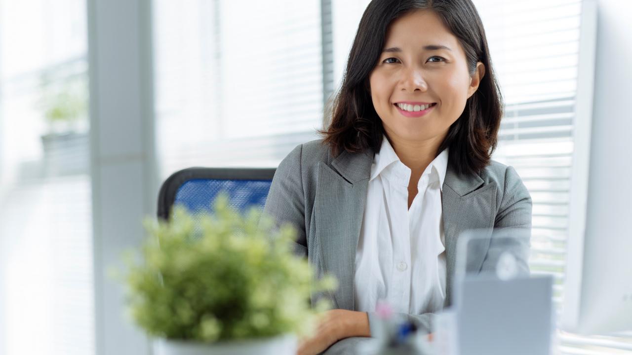 Woman sitting at desk smiling with confidence