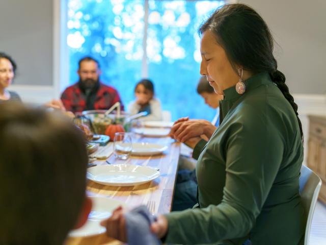 people holding hands around the dinner table