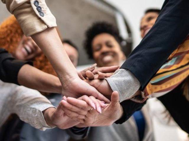 People in a circle putting their hands together