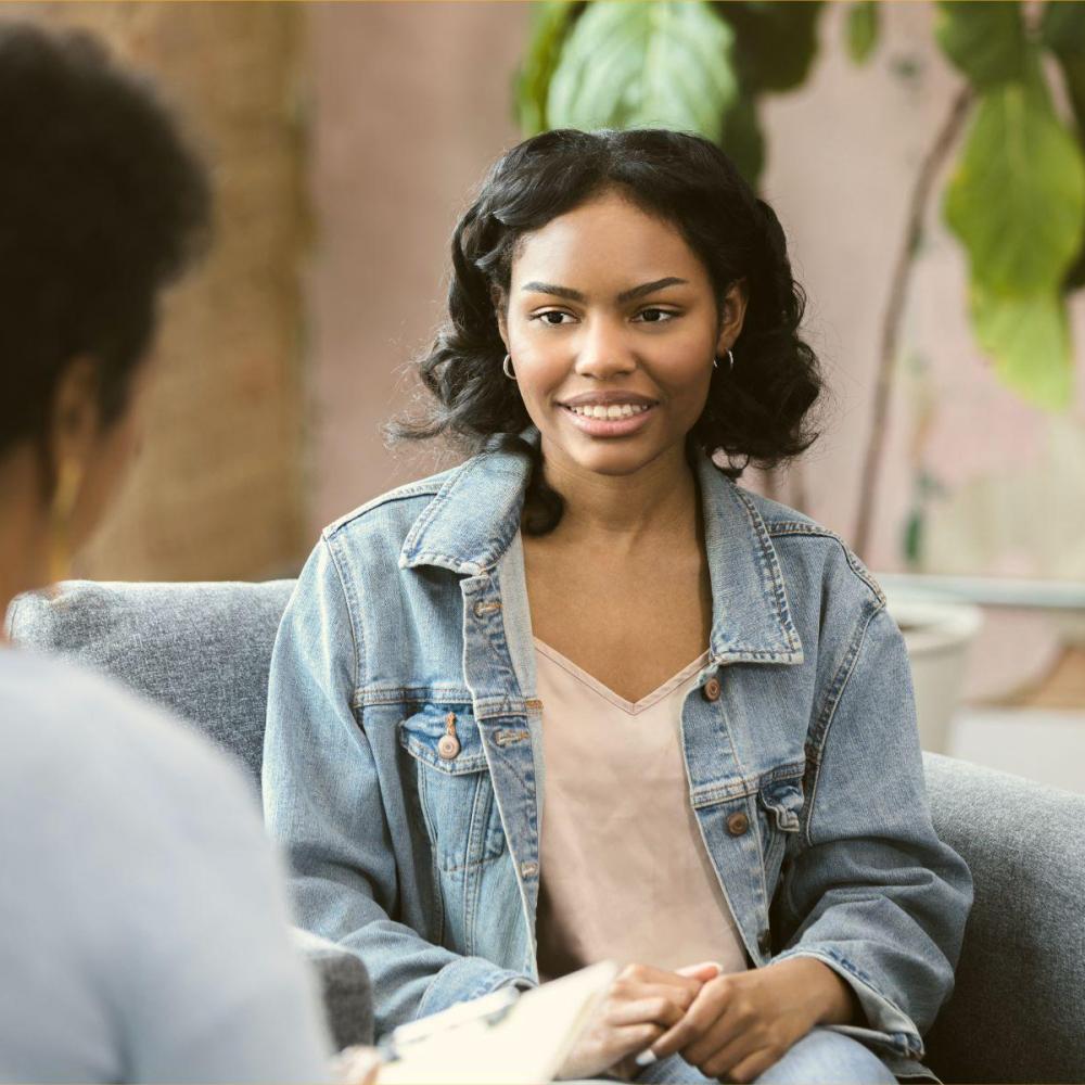 A woman in an office setting face a teenage girl.
