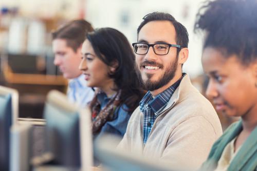 Student in a class, engaged, one is smiling