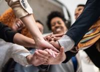 People in a circle putting their hands together