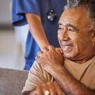 An elderly man being assisted by a helping hand.