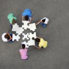 A group of people putting a giant puzzle together.