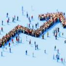 A group of people, many scattered about, but the ones grouped together form a positively progressing upward line, with a small dip in the mid-point to suggest a realistic, ending with an upward arrow. 
