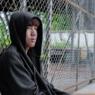Youth sitting near fence