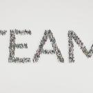 People grouped together to form the word team from overhead