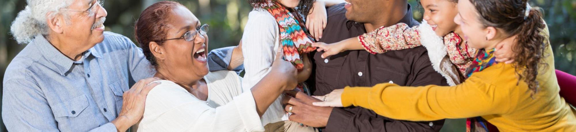 A girl being appreciated by multiple generations of caregivers.