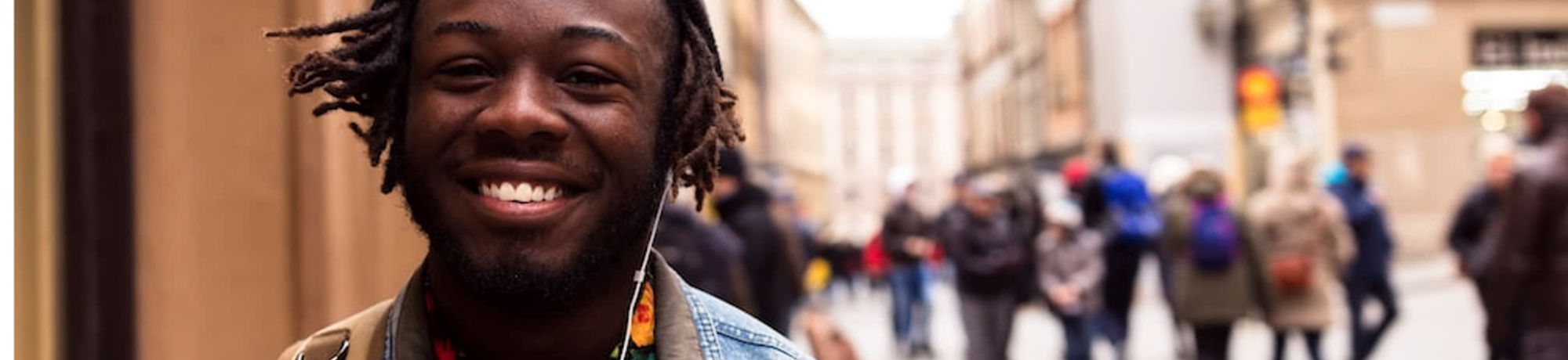 A young adult or youth smiling on a city street.